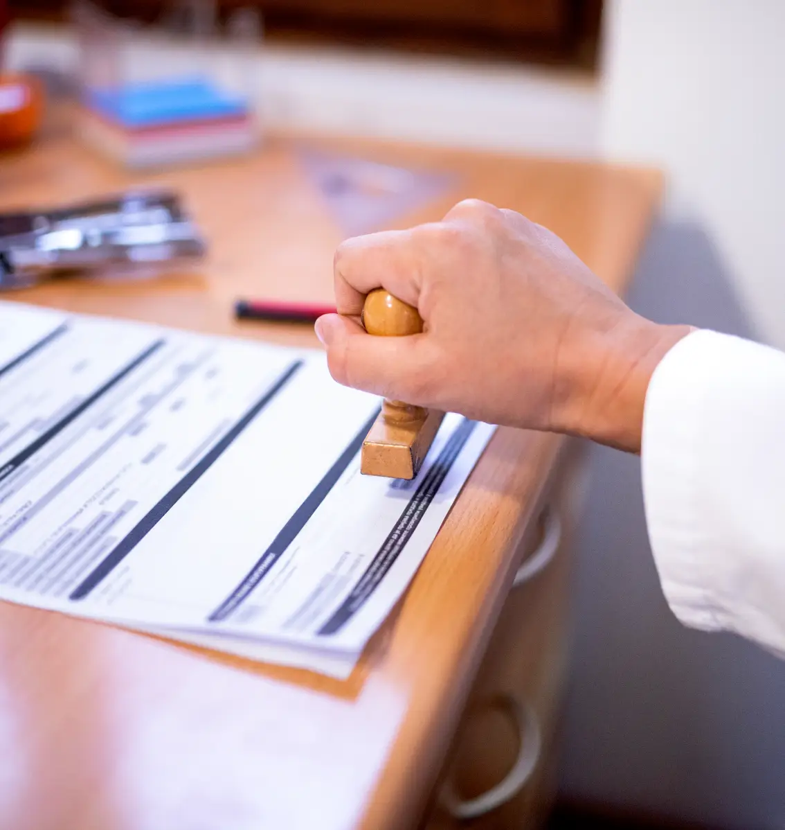 Hand stamping a document on a desk